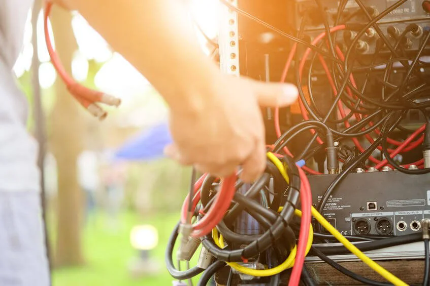 Audio engineer grabbing cables.webp.png