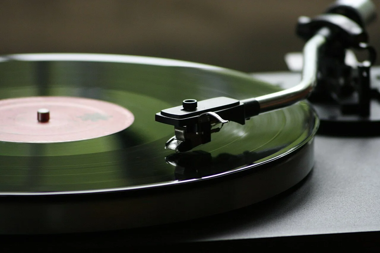 A green vinyl playing on a turntable.webp.png